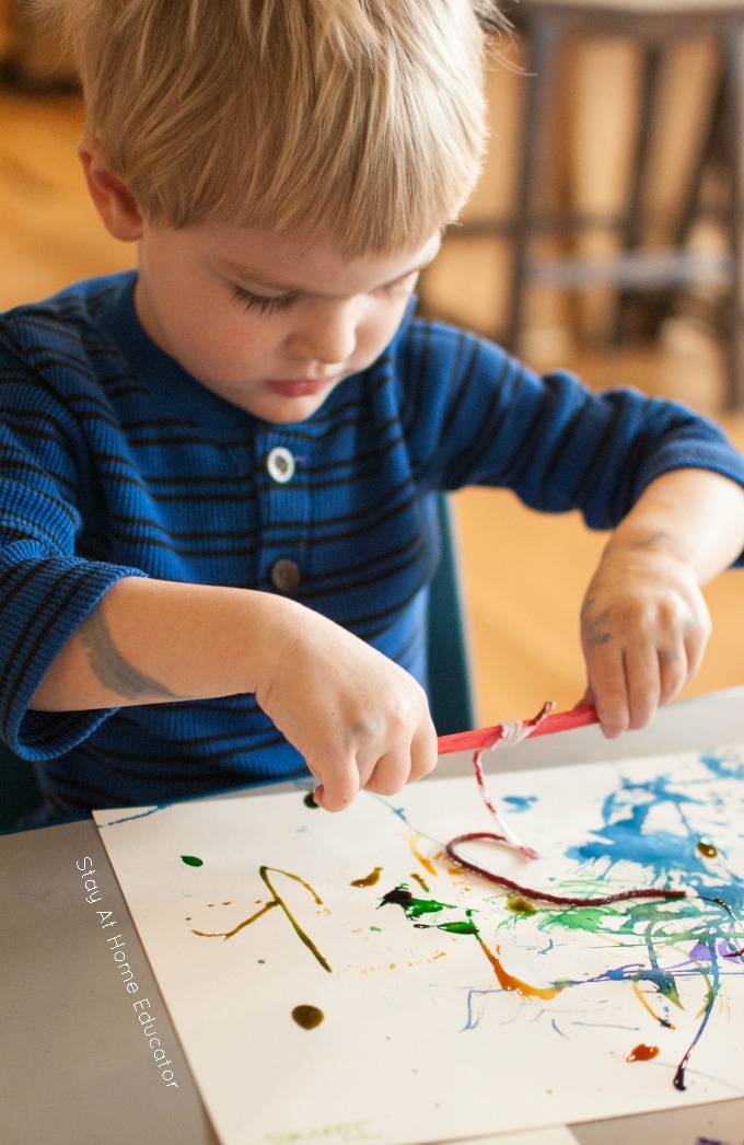 pulling the yarn on the paper - yarn paintings or string painting for kids - this is a process art activity for toddlers and preschoolers