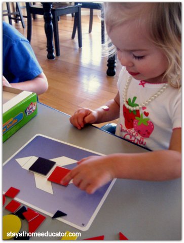 preschool girl playing with tangram cards