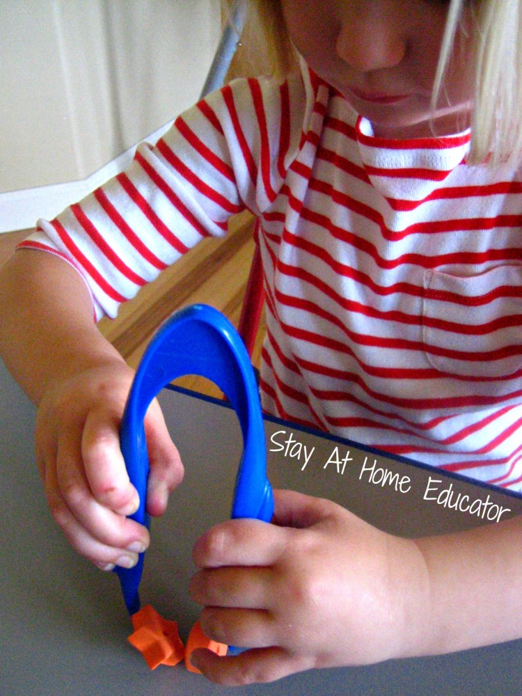 Using two hands on jumbo tweezers, fine motor activity - Stay At Home Educator