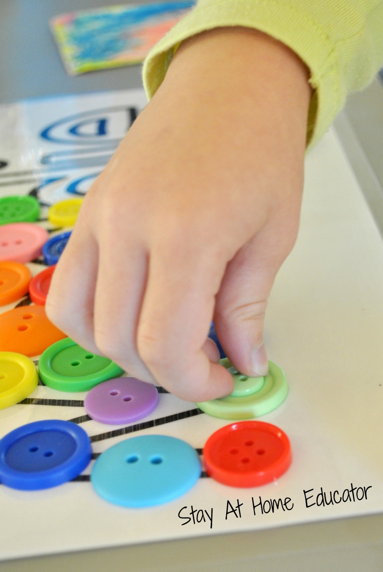 comparing button sizes during button names in preschool name recognition activity - Stay At Home Educator