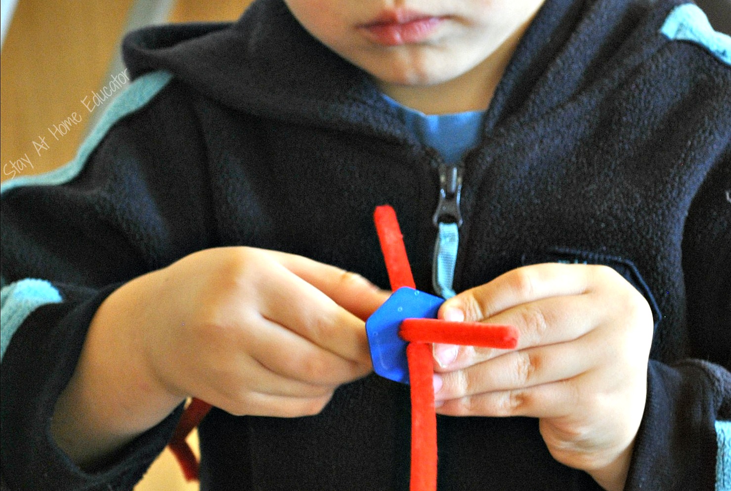 threading buttons onto pipe cleaner during open ended play - Stay At Home Educator