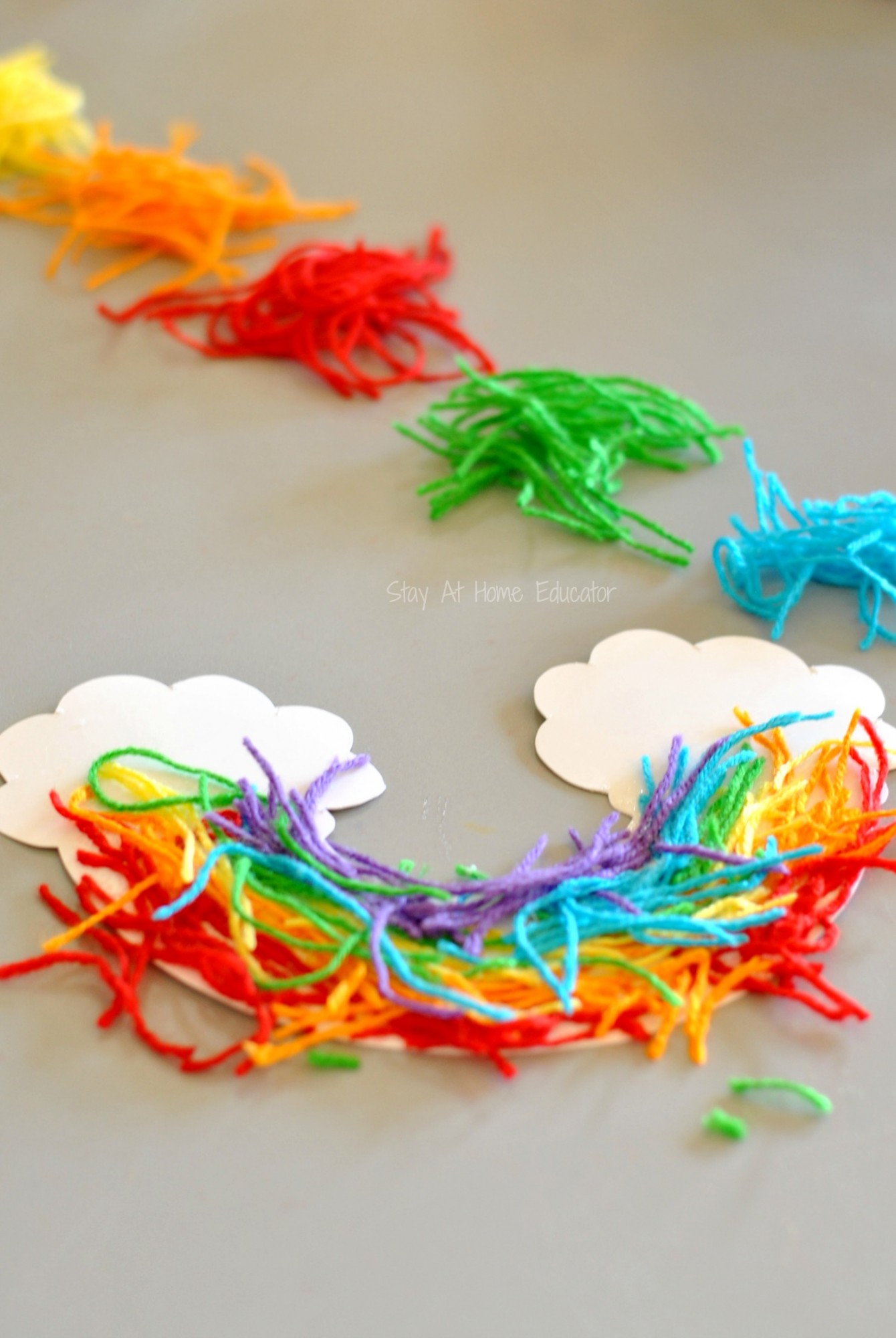 Rainbow craft for preschoolers - Snipped yarn rainbows, a fine motor craft for preschoolers  - work on hand strength, fine motor skills, and scissor cutting practice while doing a rainbow craft for preschoolers. Add it to your st. Patrick's Day lesson plans