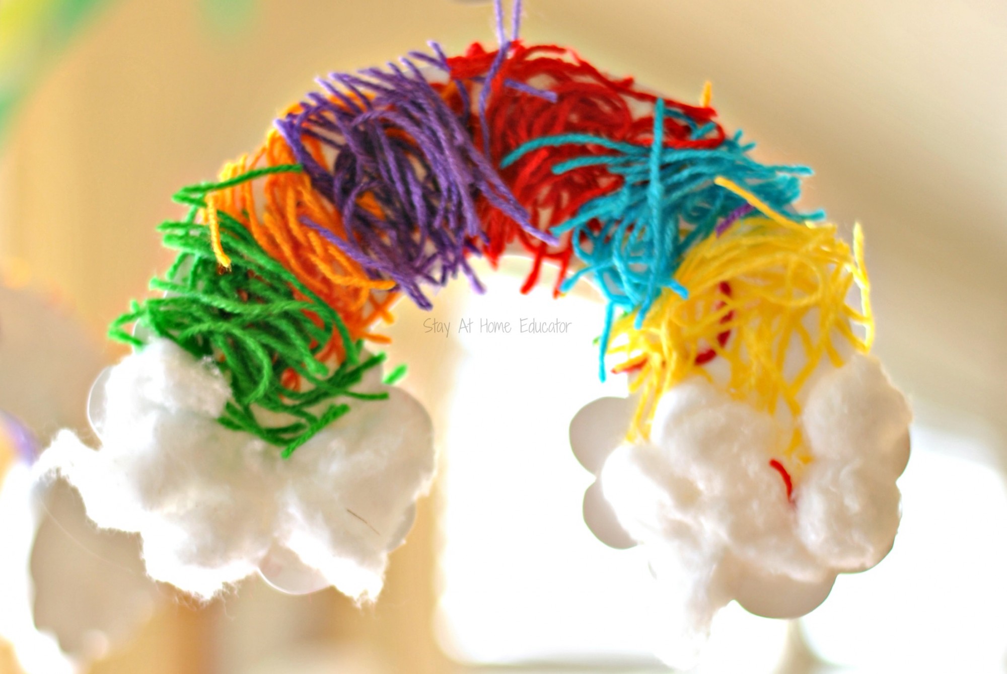 Rainbow craft of snipped yarn for fine motor skills - Snipped yarn rainbows, a fine motor craft for preschoolers  - work on hand strength, fine motor skills, and scissor cutting practice while doing a rainbow craft for preschoolers. Add it to your st. Patrick's Day lesson plans