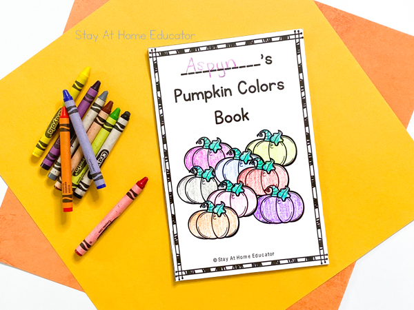 a free printable pumpkin colors book sitting next to crayons on yellow construction paper