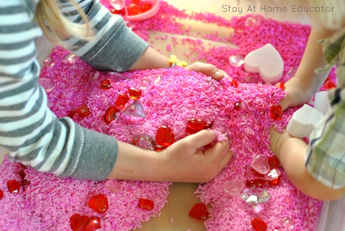 Preschoolers having fun in a valentine's day sensory bin