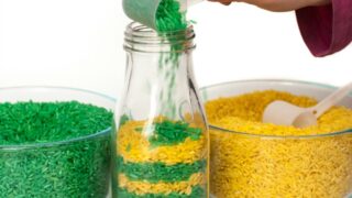 pouring and scooping activity for toddlers| making patterns by scooping and pouring green and yellow rice from two separate containers into one| excellent for developing fine motor skills for toddlers
