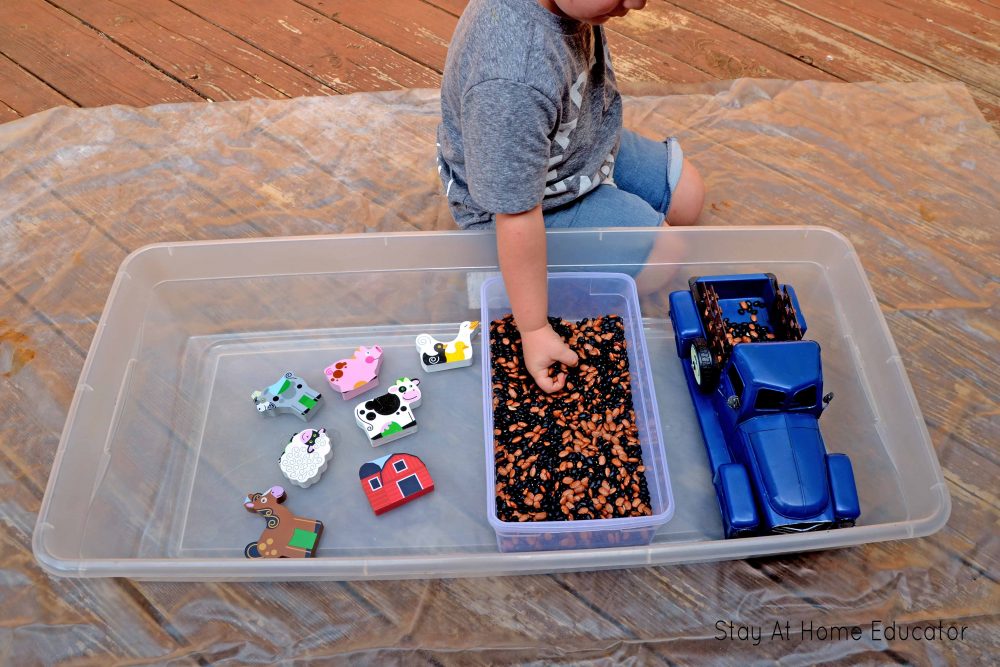 child exploring little blue truck farm theme sensory activity