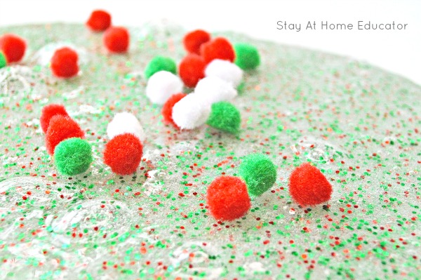 glittery borax free slime for preschoolers with pom poms sitting on top