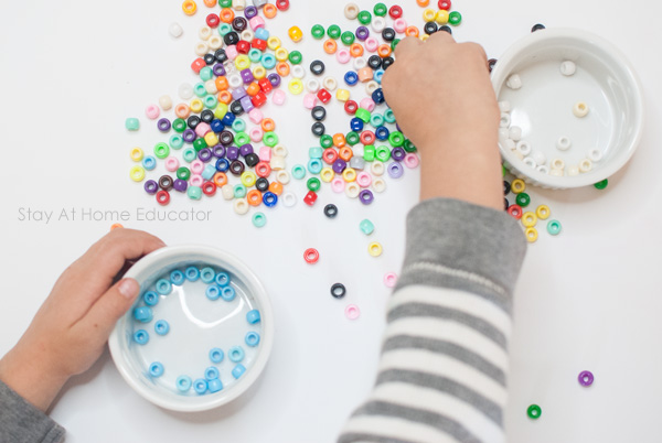preschooler practices sorting beads by color