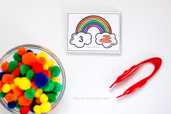 pompoms, red tweezers, and free printable rainbow cards for rainbow themed math activities