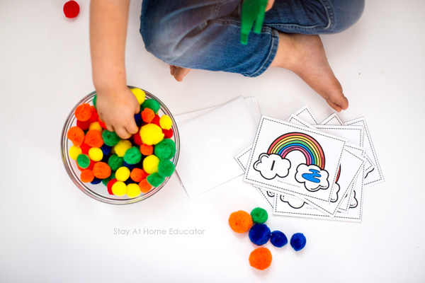 child exploring rainbow themed math activities with free printable