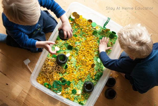 two preschoolers playing in a St. Patrick's Day sensory bin