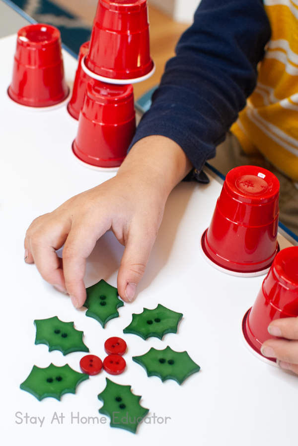 A child makes a flower pattern out of the materials provided in a Christmas invitation to play
