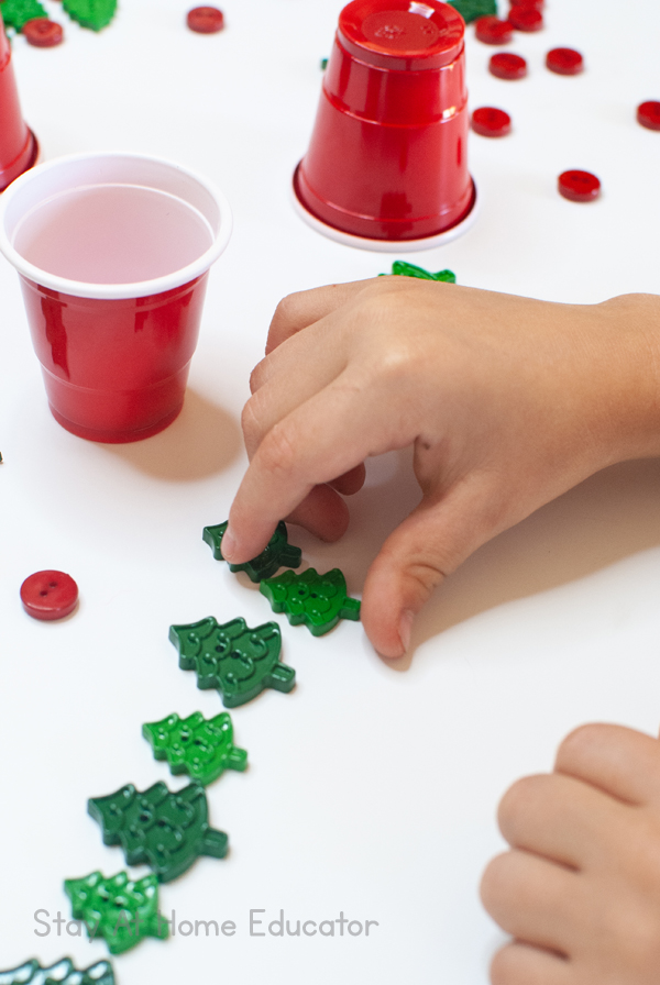 a child arranges tree-shaped buttons in rows as part of a preschool STEM activity