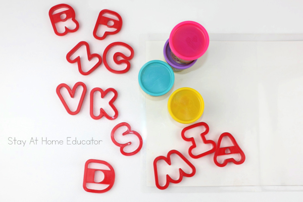 name recognition activity for preschoolers using playdough | how to teach name spelling with playdough | playdough names | writing name practice | name recognition activity for preschoolers using playdough | image of playdough and alphabet cookie cutters to make names