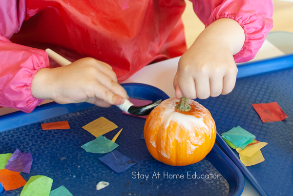 | tissue painted fall pumpkin | process art activity for preschoolers | painting glue on pumpkin to stick tissue paper |