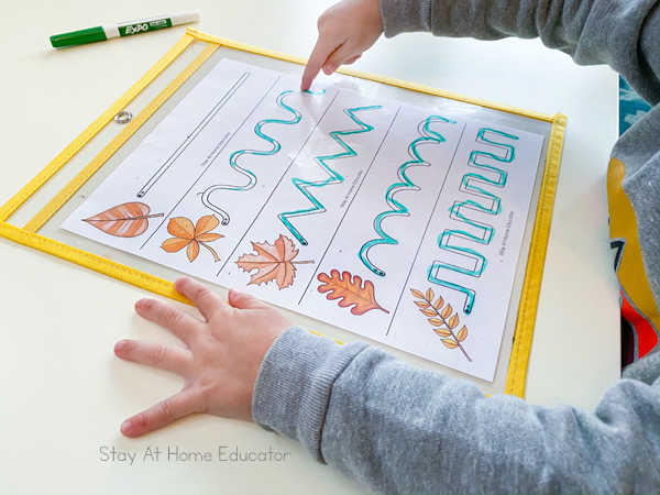 pre writing activities | prewriting worksheets | prewriting strokes | activities to teach preschool writing | preschool fall theme | fall leaves preschool activities | toddler using finger to trace lines on dry erase 