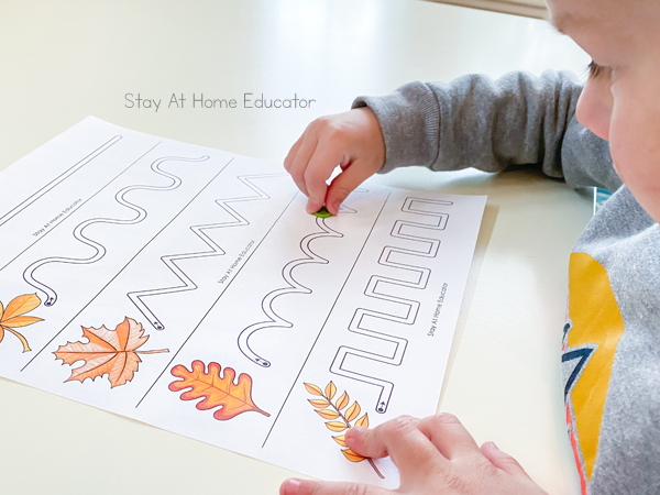 pre writing activities | prewriting worksheets | prewriting strokes | activities to teach preschool writing | preschool fall theme | fall leaves preschool activities | toddler using button to push along the tracing lines