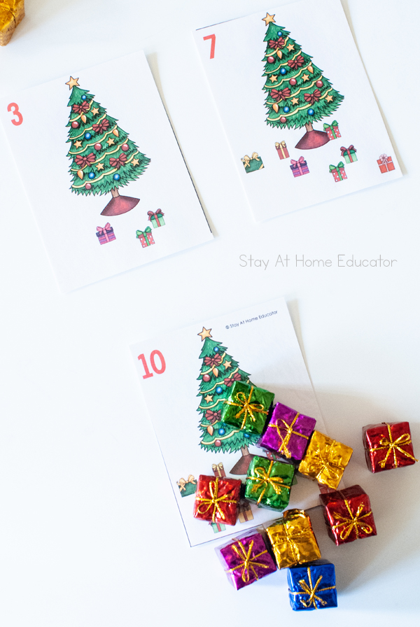 Free Christmas Counting Cards| Image shows three Christmas tree counting cards, with numeral 3, 7, and 10| Image has mini gift manipulatives to compose and decompose the numbers|