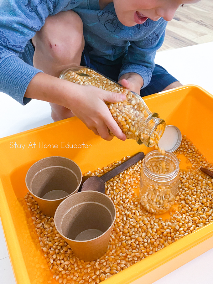 scooping and pouring activity for toddlers | benefits of scooping and pouring activities for toddlers | fine motor skills for toddlers | toddler pouring corn kernels into a bottle