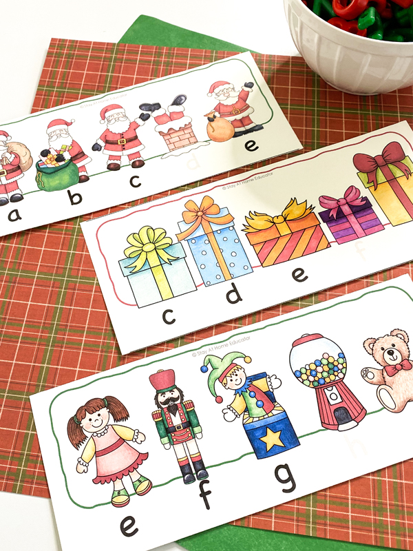 three free printable ABC order cards lying on a colorful Christmas background