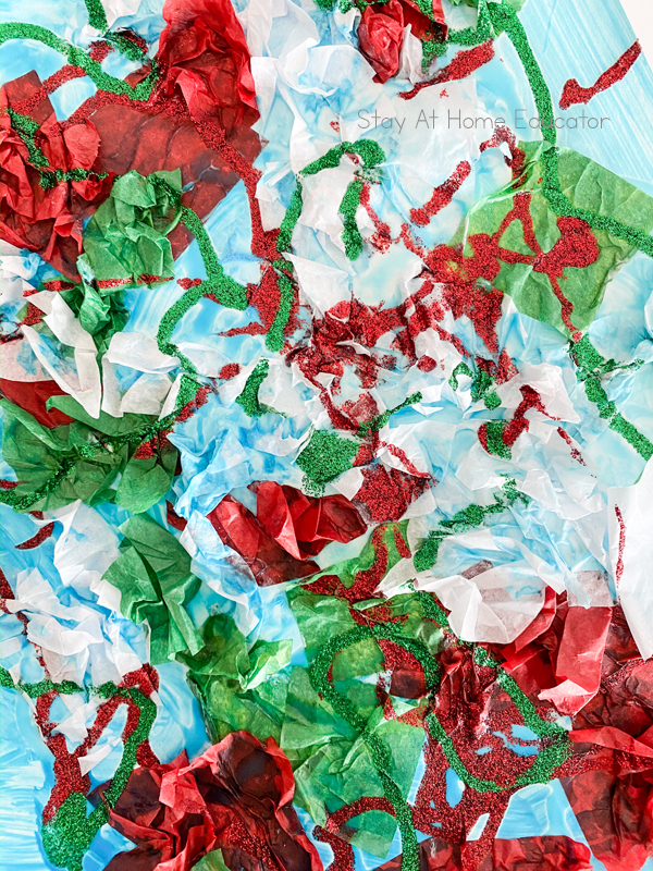 red, white, and green tissue paper and glitter glue on a blue painted canvas make gorgeous Christmas art for preschoolers