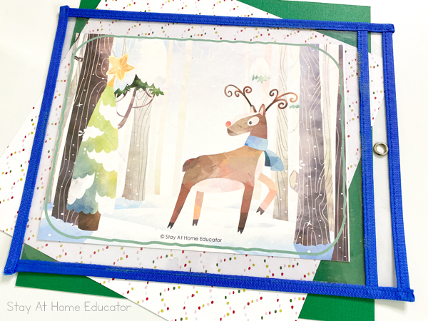 a Christmas printable sits in a dry erase pouch with a blue border