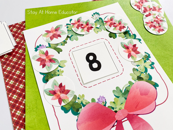 a Christmas counting activity of a printable wreath mat with the number 8 in it and flower cards that add up to 8