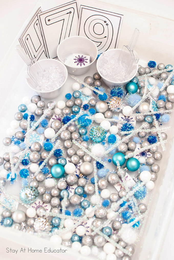 overview of a winter sensory exploration bin with pompoms, sparkly gems and balls, and pipe cleaners