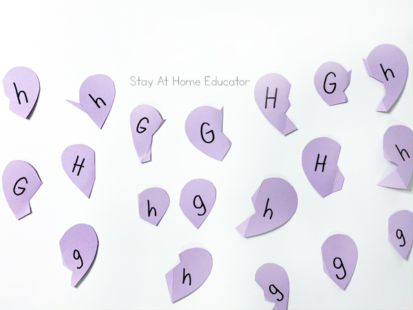 all of the heart halves with letters on them set out for an alphabet learning activity