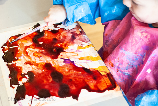 a boy uses a lot of liquid watercolor to create his valentines art activity for toddlers