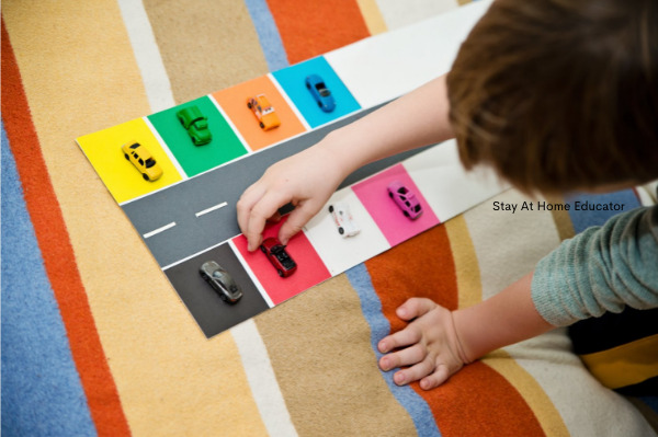 colored toy cars matched up with a colored parking space showing a creative way to teach one to one correspondence