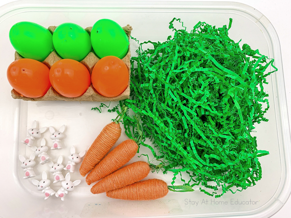 the materials of an easter egg sensory bin are neatly arranged and ready for preschoolers to dive in