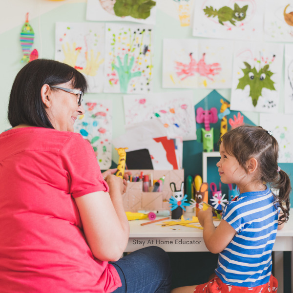 a teacher working individually with a child as they complete the lesson planned in the preschool lesson plans template