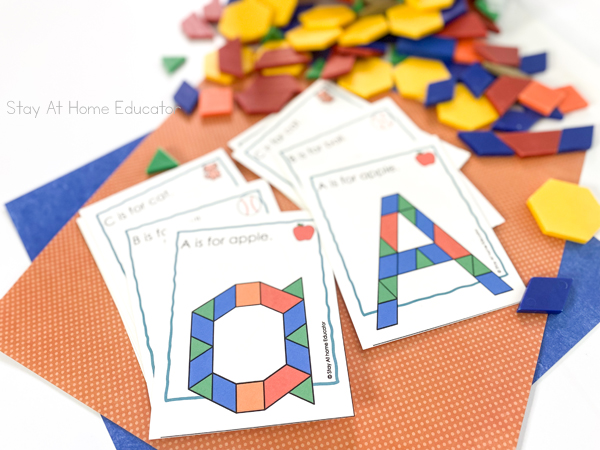 alphabet pattern blocks printable task cards| alphabet pattern block mats | task card with lowercase a and task card with capital A, both with sentence: A is for apple and apple picture on top| More task cards loosely stacked under with faded look for effect| assorted pattern blocks next to task cards with faded look for effect