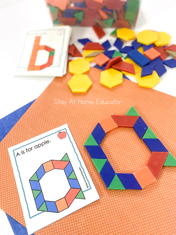 alphabet pattern blocks printable task card| alphabet activities| lowercase a pattern blocks task card with sentence: A is for apple and apple image| pattern blocks forming lowercase a next to the task card| lowercase b task card faded for effect| assorted pattern blocks next to lowercase b task card 