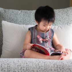 a child build preschool reading skills by looking at the pictures in a book and re-telling the story.