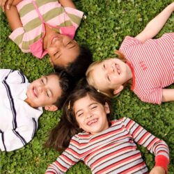 children lying in grass with text preschool lesson plans for all about me theme - free | September preschool themes |