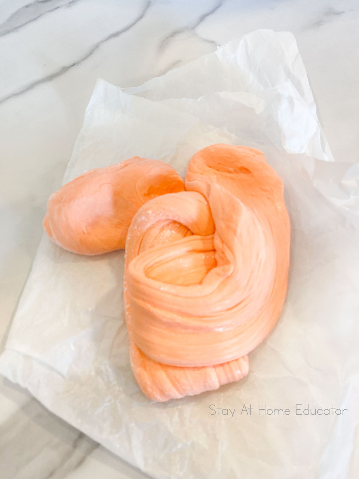 Soft, stretchy edible playdough made from marshmallows. Orange playdough. 