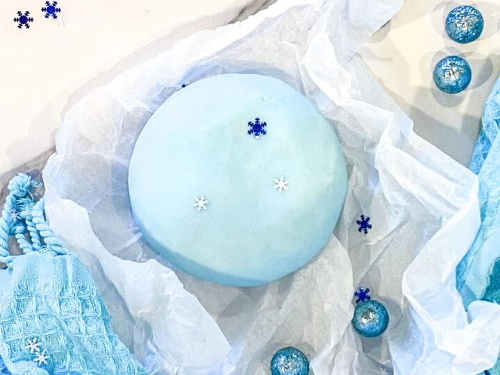 best peppermint playdough recipe | how to make peppermint playdough | ball of peppermint playdough on parchment paper with blue cloth