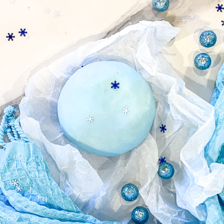 best peppermint playdough recipe | how to make peppermint playdough | ball of peppermint playdough on parchment paper with blue cloth
