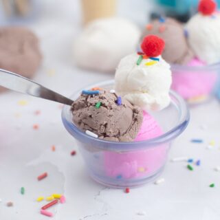 A colorful picture of a sundae dish filled with ice cream playdough that looks just like real Neapolitan flavors, with layers of chocolate, vanilla, and strawberry. This playful playdough recipe, which looks and scoops like real ice cream, is a fun and educational activity, great for teaching preschoolers about ice cream.
