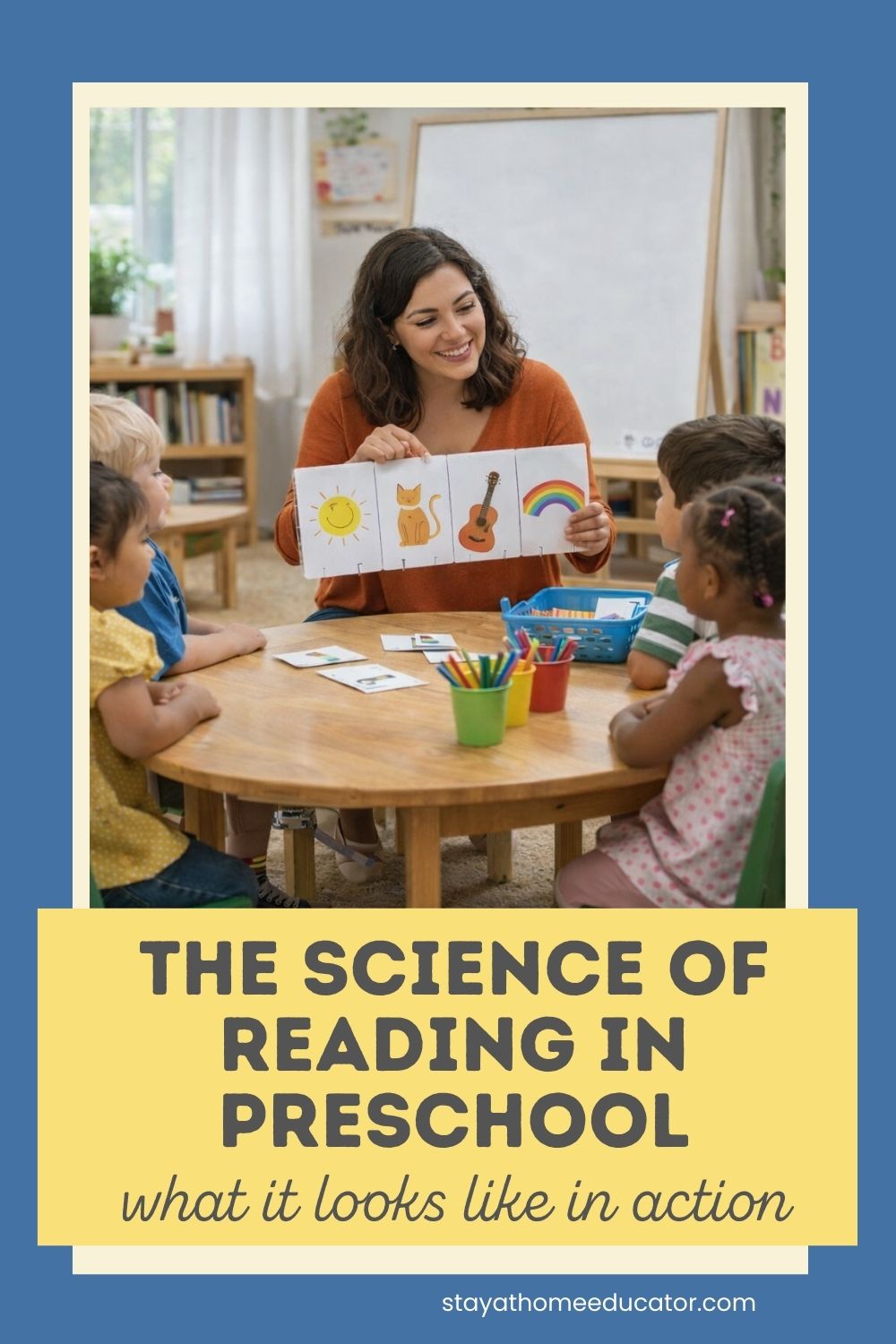 Preschool teacher holding picture cards with simple images while sitting at a small round table with four young children during a phonics and early literacy small group lesson.